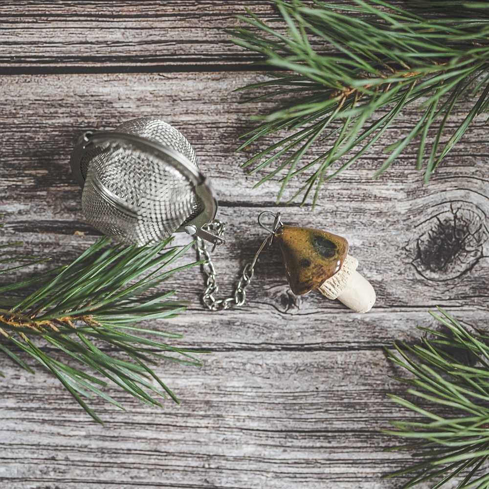 Tea infuser with ceramic brown mushroom hanging from the chain.