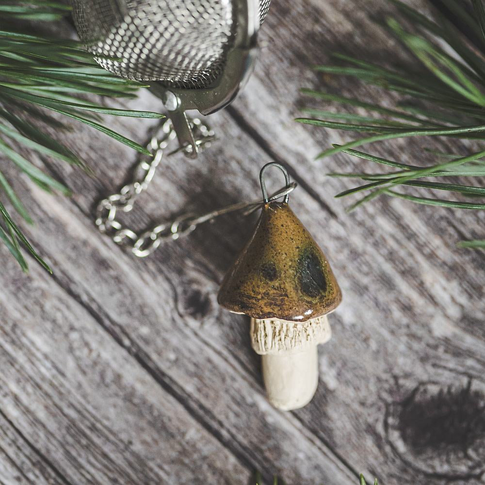 Tea infuser with ceramic brown mushroom hanging from the chain.