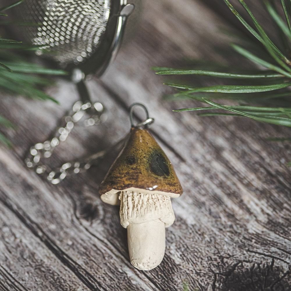 Tea infuser with ceramic brown mushroom hanging from the chain.