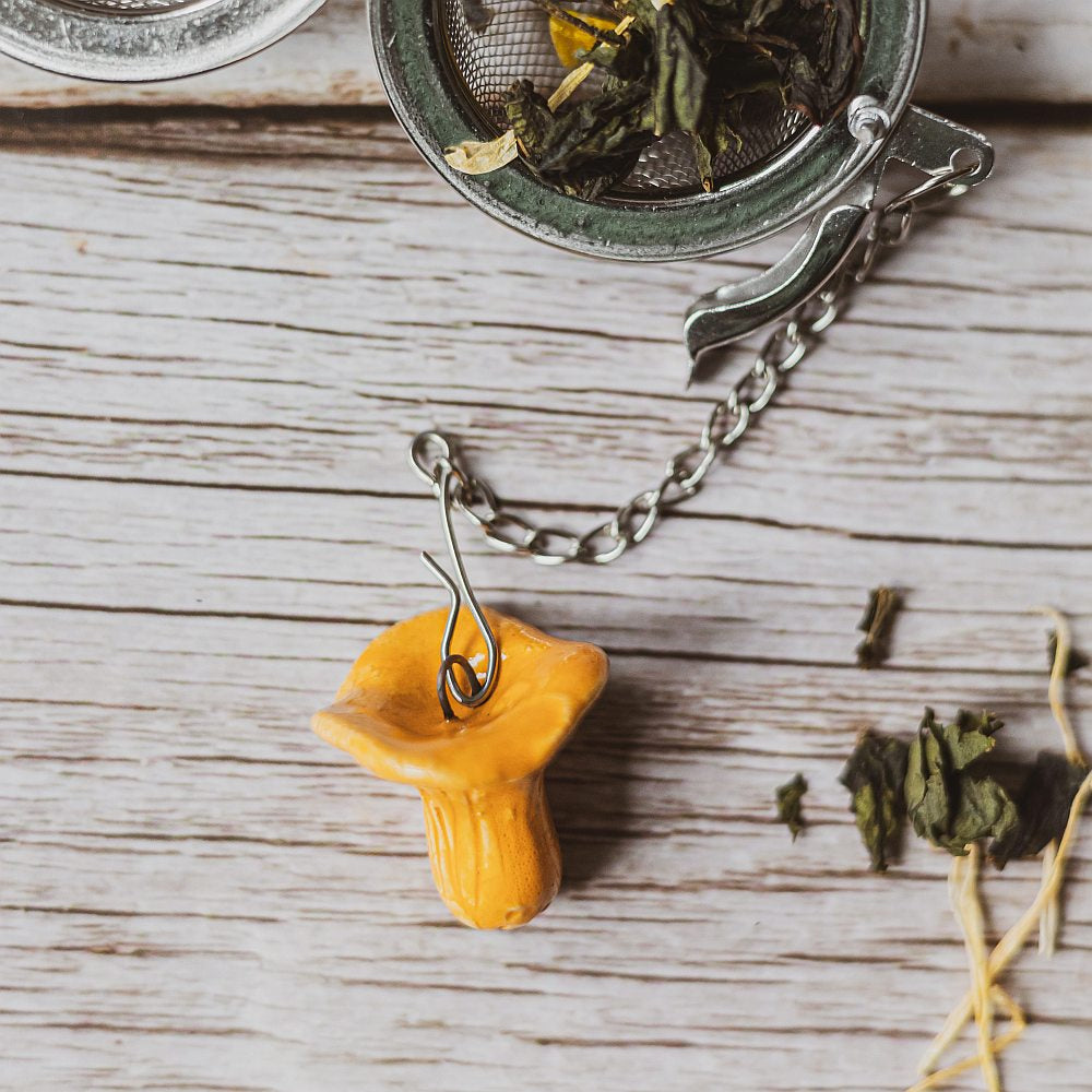 tea infuser with ceramic chanterelle mushroom hanging from the chain
