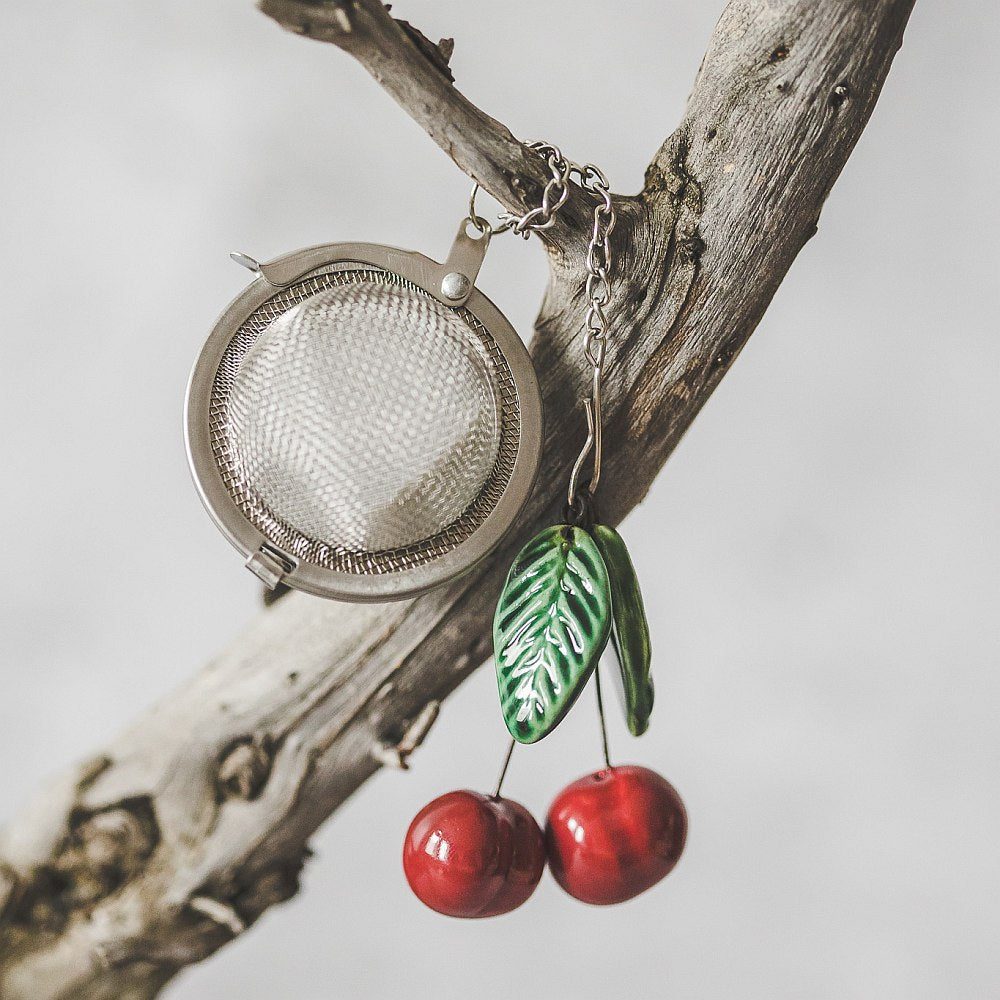 Tea infuser with ceramic cherries hanging from the chain.
