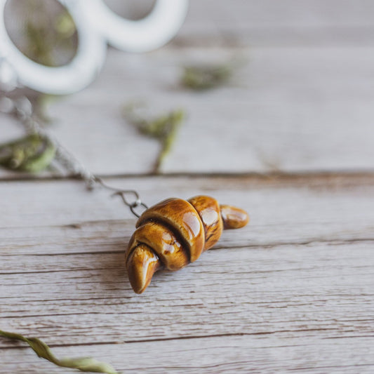 Tea infuser with ceramic croissant hanging from the chain