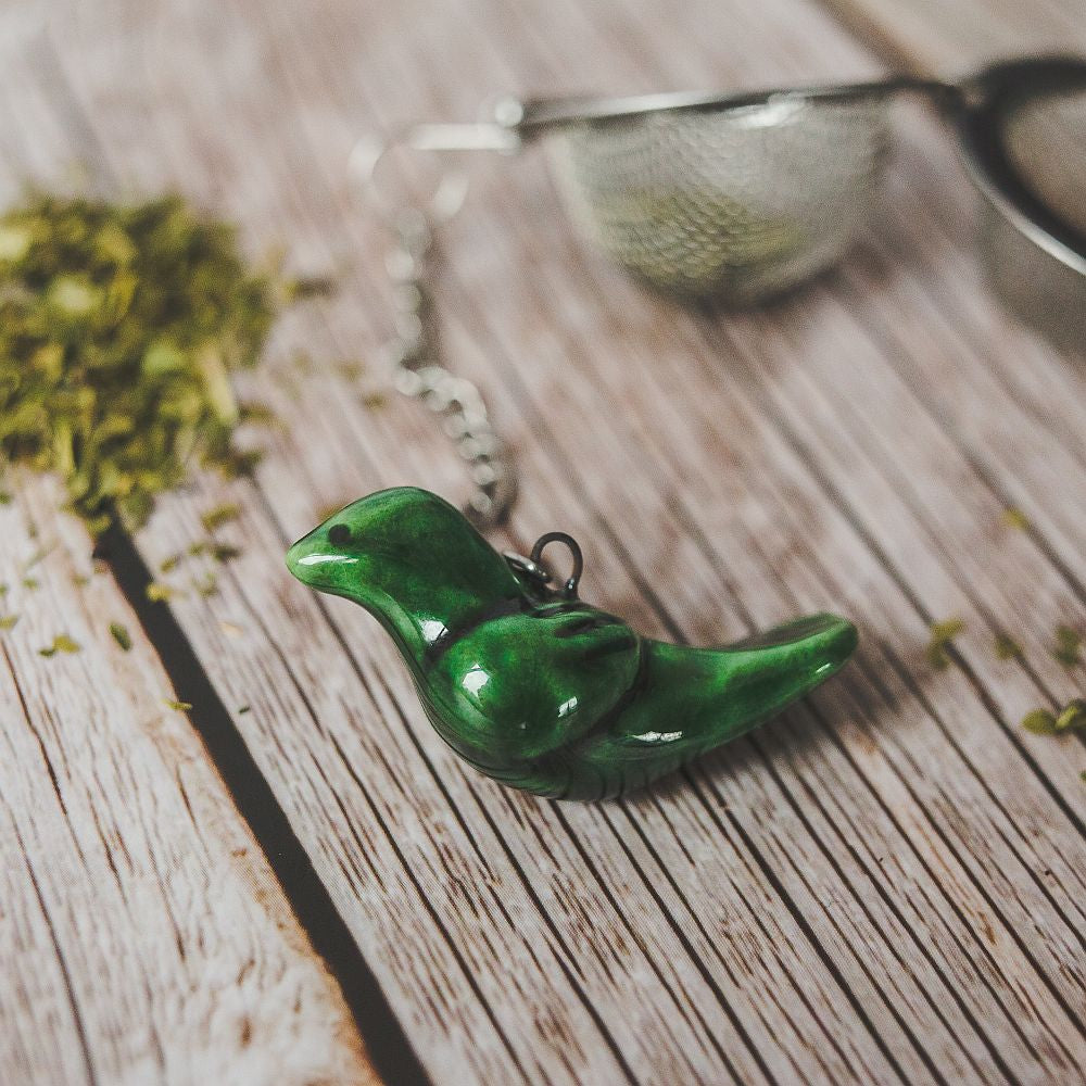 Tea infuser with ceramic green bird hanging from the chain.