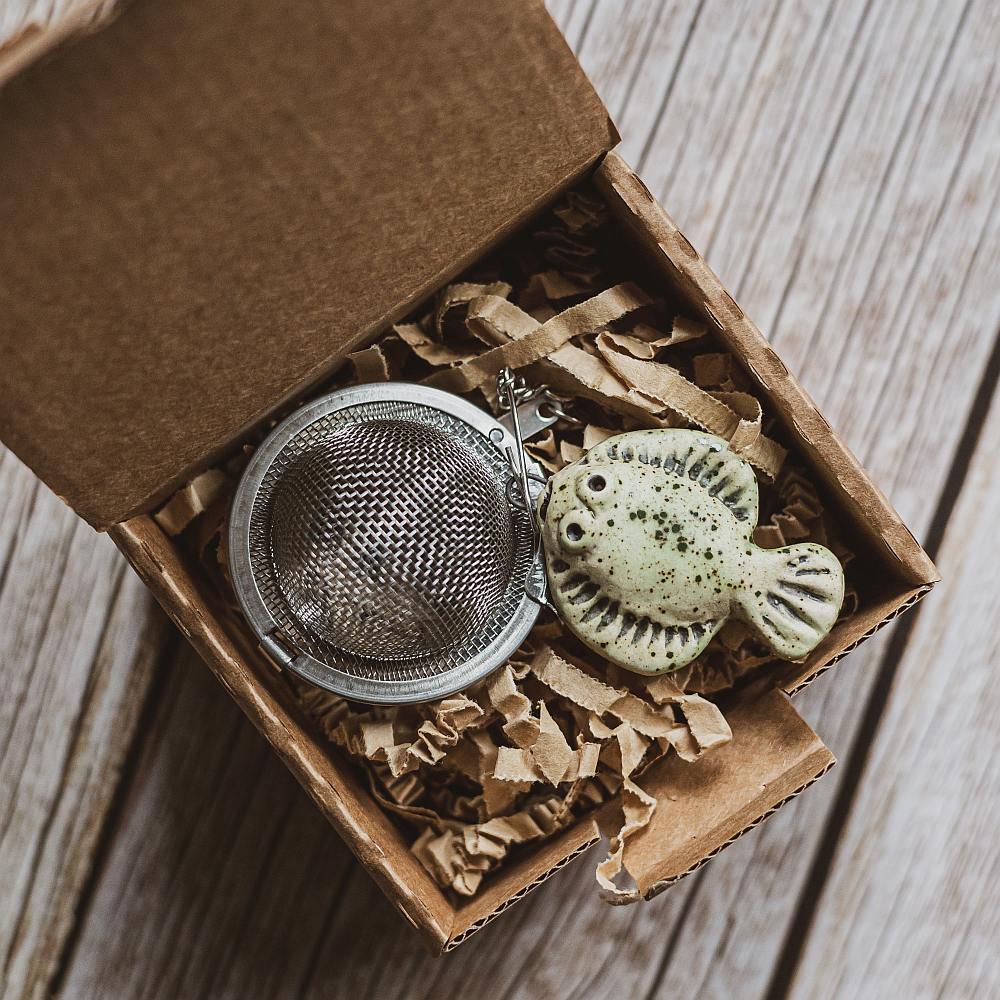 tea infuser with ceramic green flatfish hanging from the chain