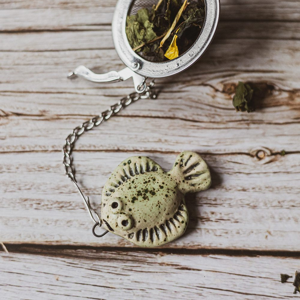 tea infuser with ceramic green flatfish hanging from the chain
