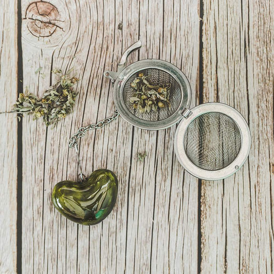 Tea infuser with ceramic green heart hanging from the chain.