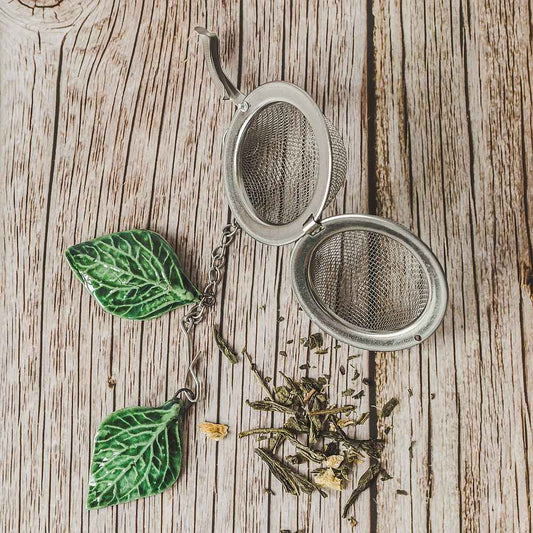 Tea infuser with ceramic green leaves hanging from the chain.