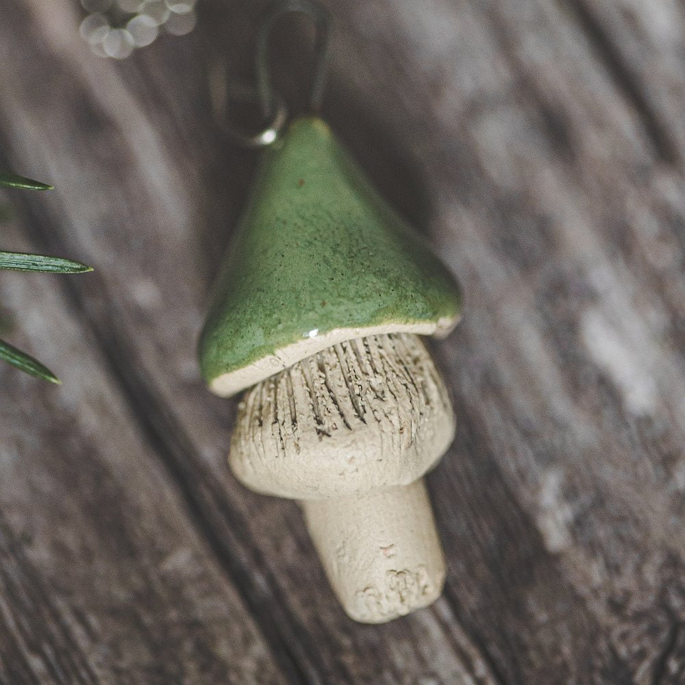 Tea infuser with ceramic green mushroom hanging from the chain.