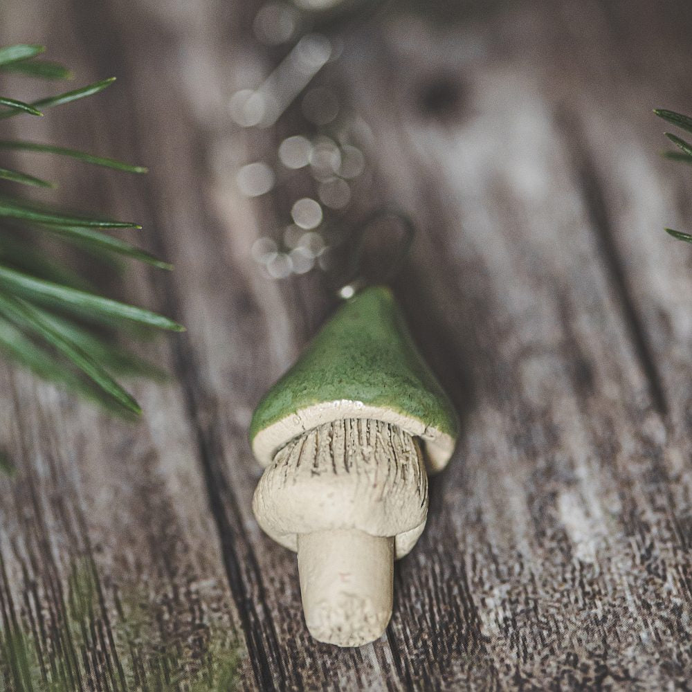 Tea infuser with ceramic green mushroom hanging from the chain.
