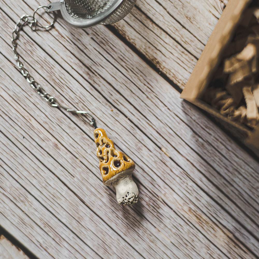 Tea infuser with ceramic gyromitra mushroom hanging from the chain.
