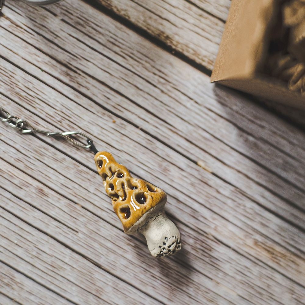 Tea infuser with ceramic gyromitra mushroom hanging from the chain.