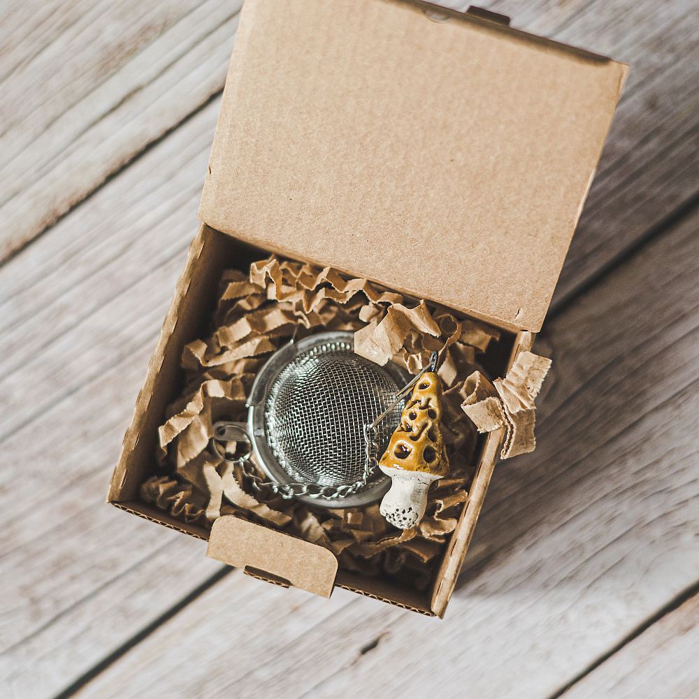 Tea infuser with ceramic gyromitra mushroom hanging from the chain.