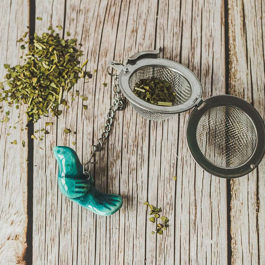 Tea infuser with ceramic light blue bird hanging from the chain.