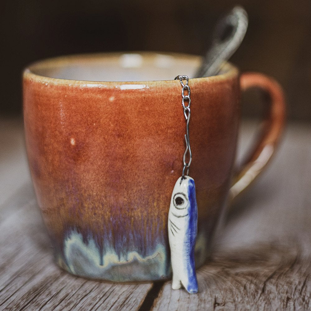 tea infuser with ceramic long fish hanging from the chain