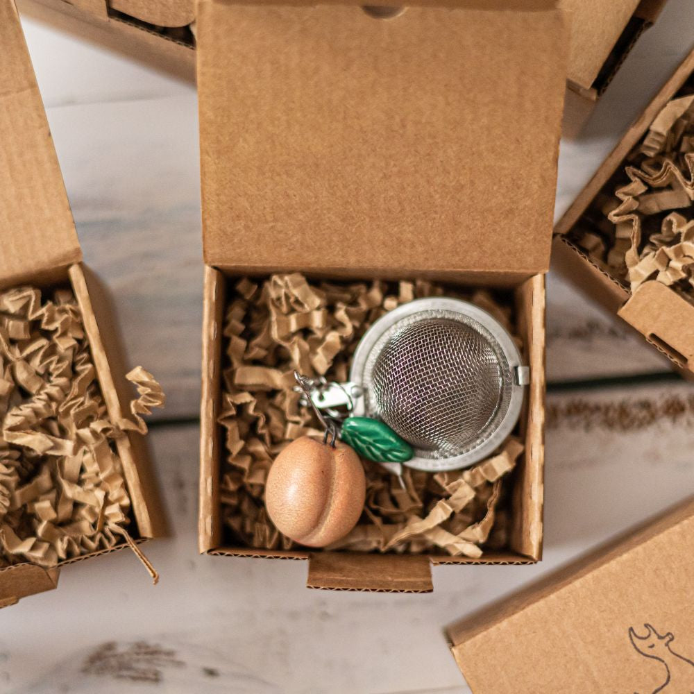 tea infuser with ceramic peach hanging from the chain