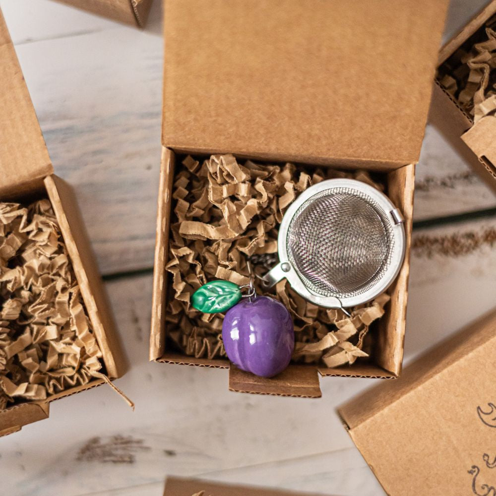 tea infuser with ceramic blue plum hanging from the chain