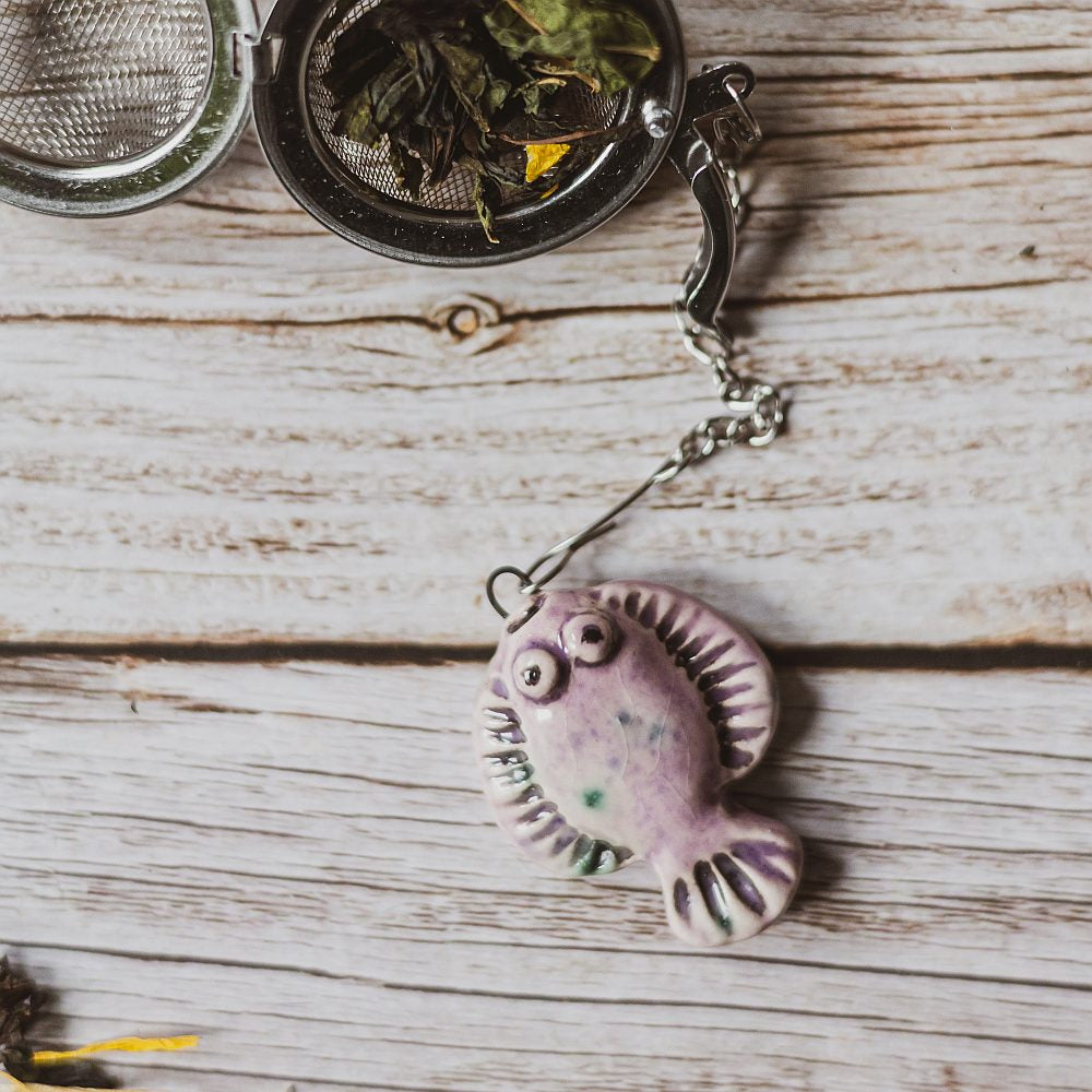 tea infuser with ceramic purple flatfish hanging from the chain