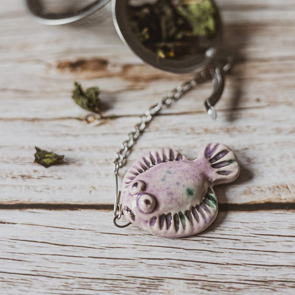 tea infuser with ceramic purple flatfish hanging from the chain