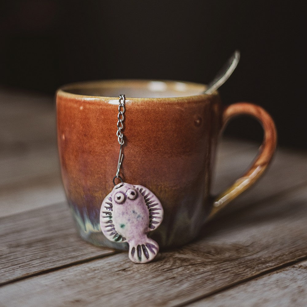 tea infuser with ceramic purple flatfish hanging from the chain