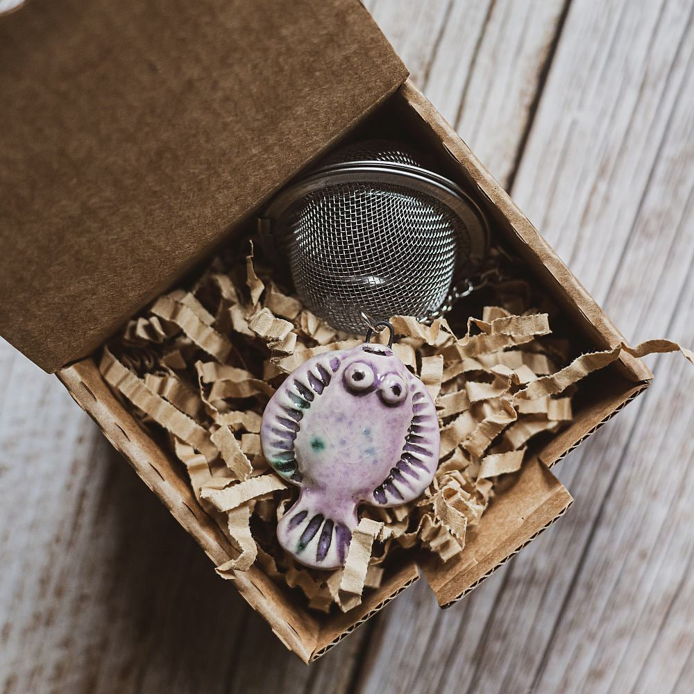 tea infuser with ceramic purple flatfish hanging from the chain