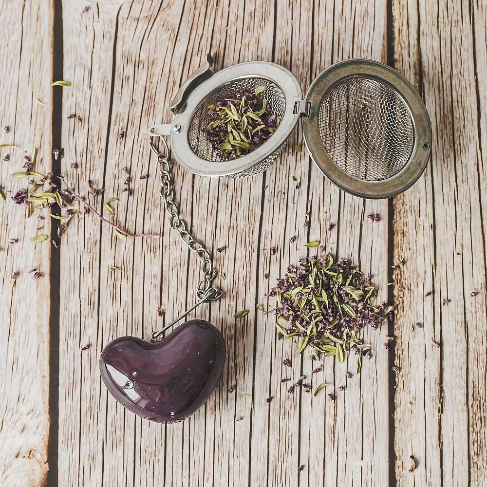 Tea infuser with ceramic purple heart hanging from the chain.