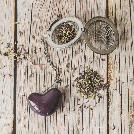 Tea infuser with ceramic purple heart hanging from the chain.