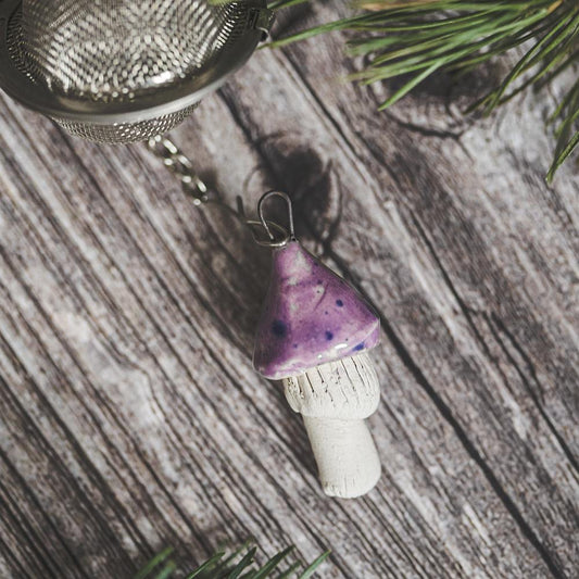 Tea infuser with ceramic purple mushroom hanging from the chain.