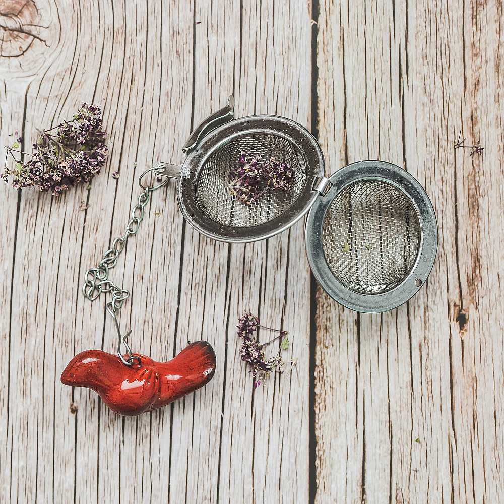 Tea infuser with ceramic red bird hanging from the chain.