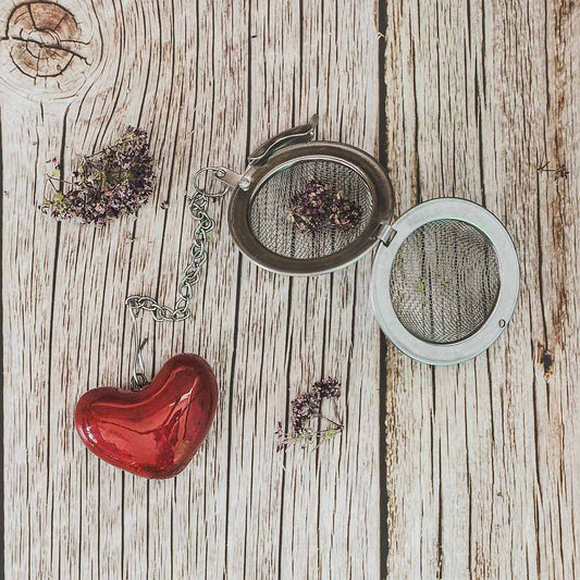 Tea infuser with ceramic red heart hanging from the chain.