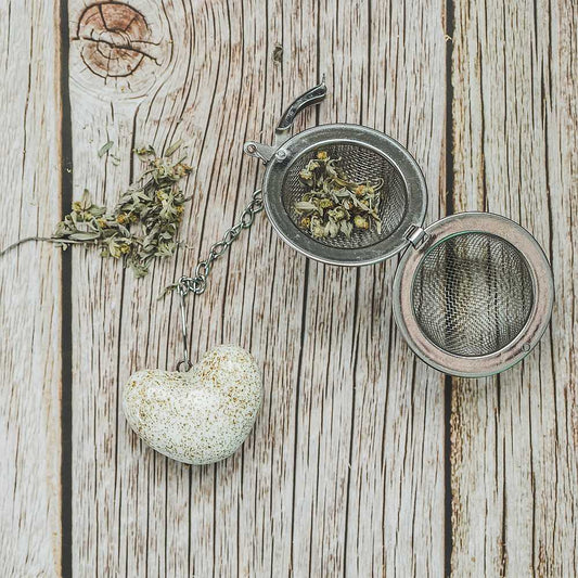 Tea infuser with ceramic white heart hanging from the chain.