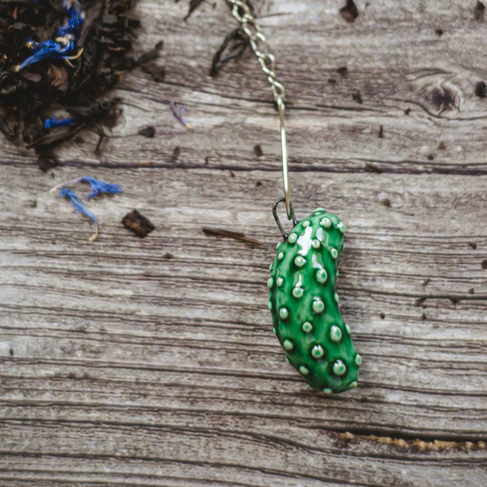 tea infuser with ceramic cucumber hanging from the chain
