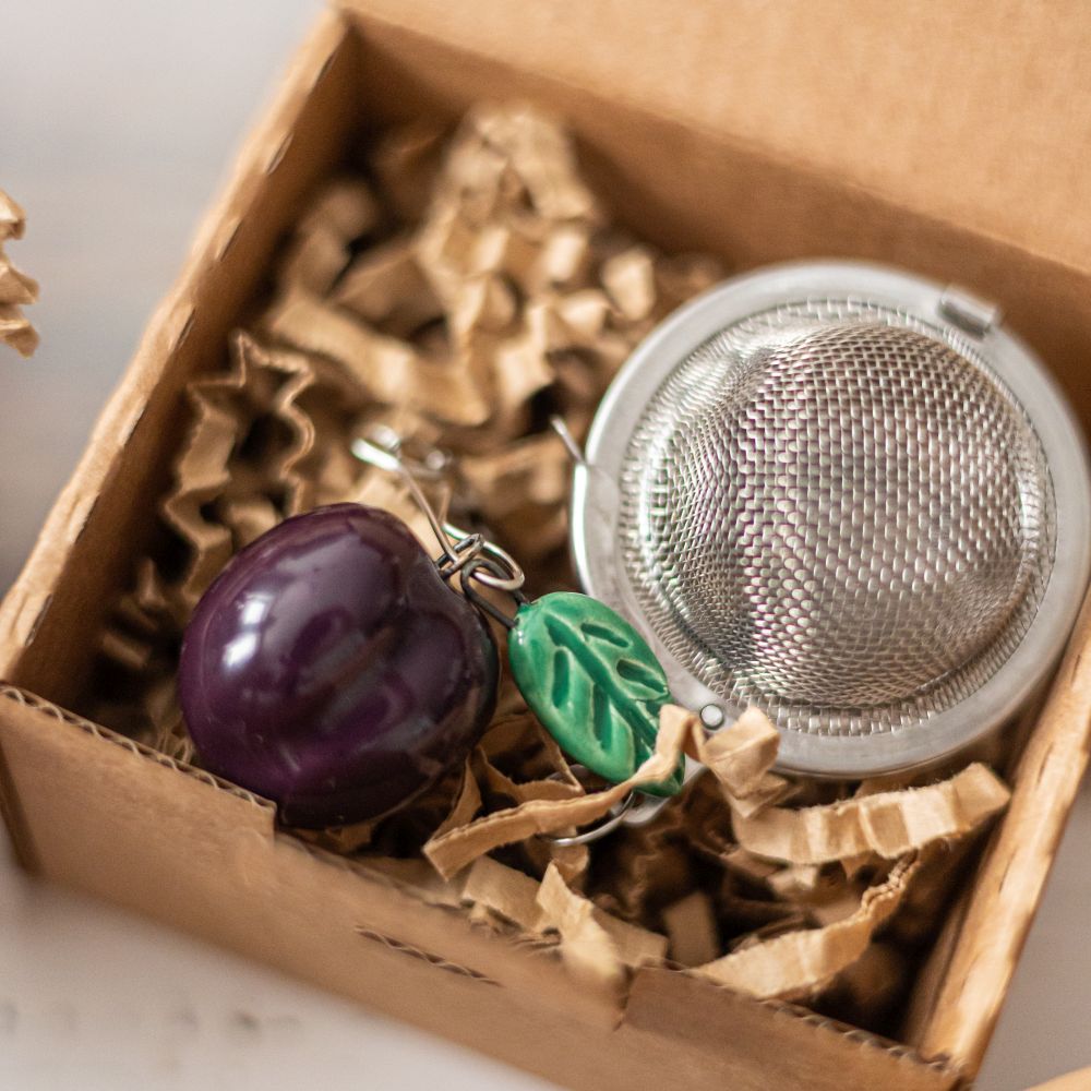 tea infuser with ceramic purple plum hanging from the chain