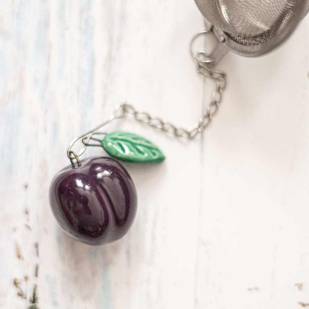 tea infuser with ceramic purple plum hanging from the chain