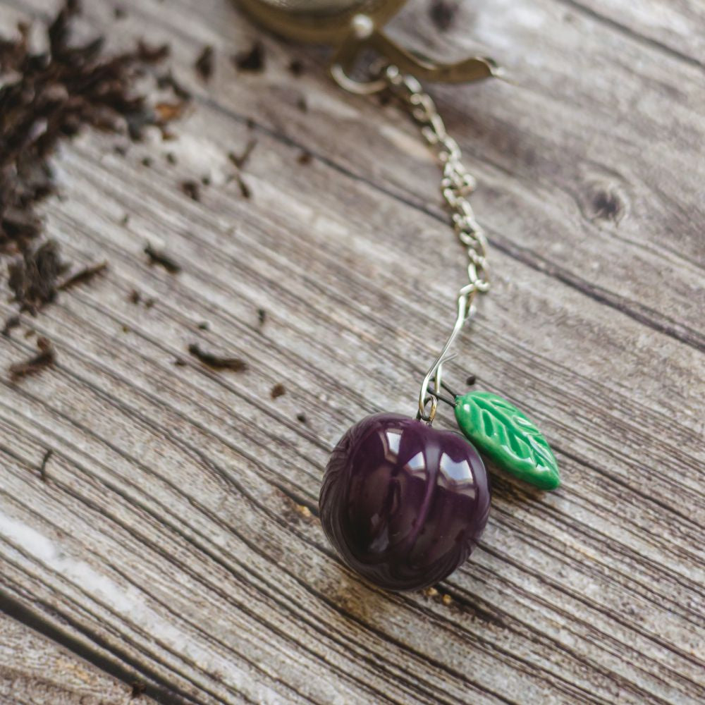 tea infuser with ceramic purple plum hanging from the chain