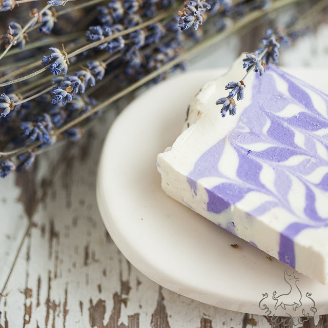 Handmade ceramic oval soap dish. Crafted from white clay and finished with a glossy white glaze. Designed with drainage holes, a concave shape, and four little feet.