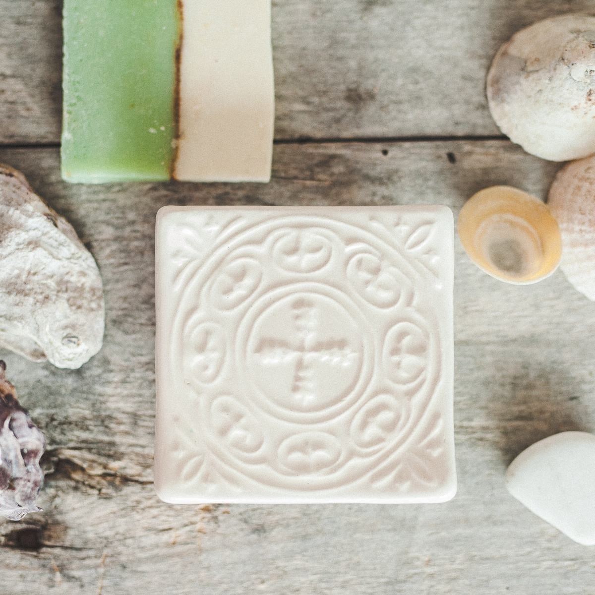 Handmade ceramic square soap dish. Crafted from white clay and finished with a glossy white glaze. Designed with drainage holes, a concave shape, and four little feet.