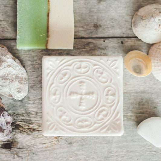 Handmade ceramic square soap dish. Crafted from white clay and finished with a glossy white glaze. Designed with drainage holes, a concave shape, and four little feet.